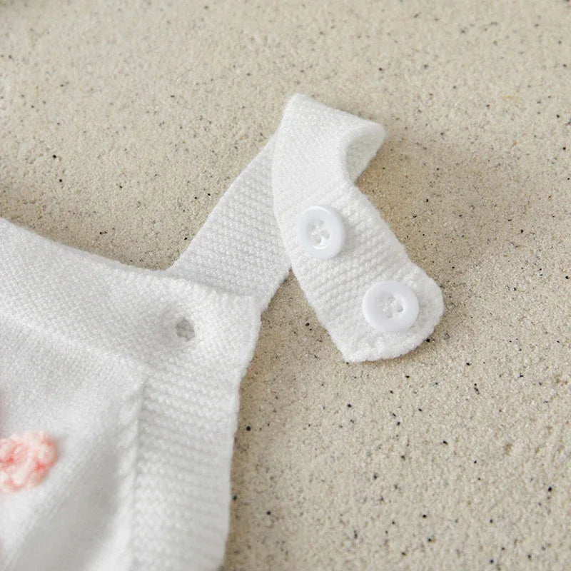 White knit baby birthday romper strap with two white buttons for infants