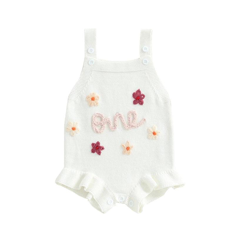 White baby birthday romper with pink one embroidery and multicolor flower details for infants