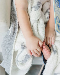 Soft creamy white and charcoal gray baby blanket with graceful heron print, showcasing coastal elegance and plush comfort.