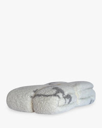 Folded creamy white baby blanket featuring a light charcoal heron print for coastal comfort.