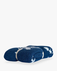 Folded navy blue baby blanket featuring white sea turtle design against deep blue backdrop.