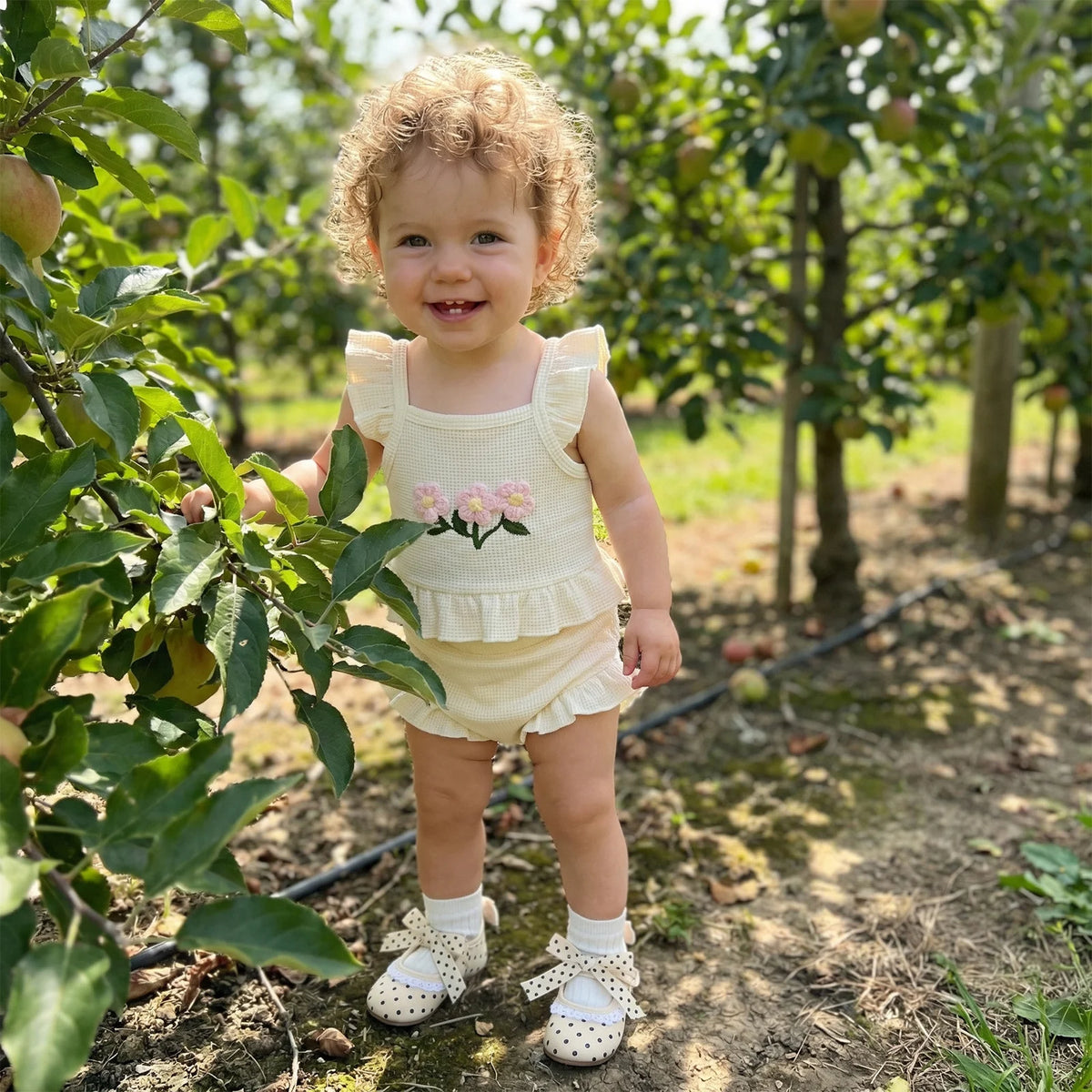 cream baby girl outfit with pink flower embroidery and ruffled sleeves for toddler size