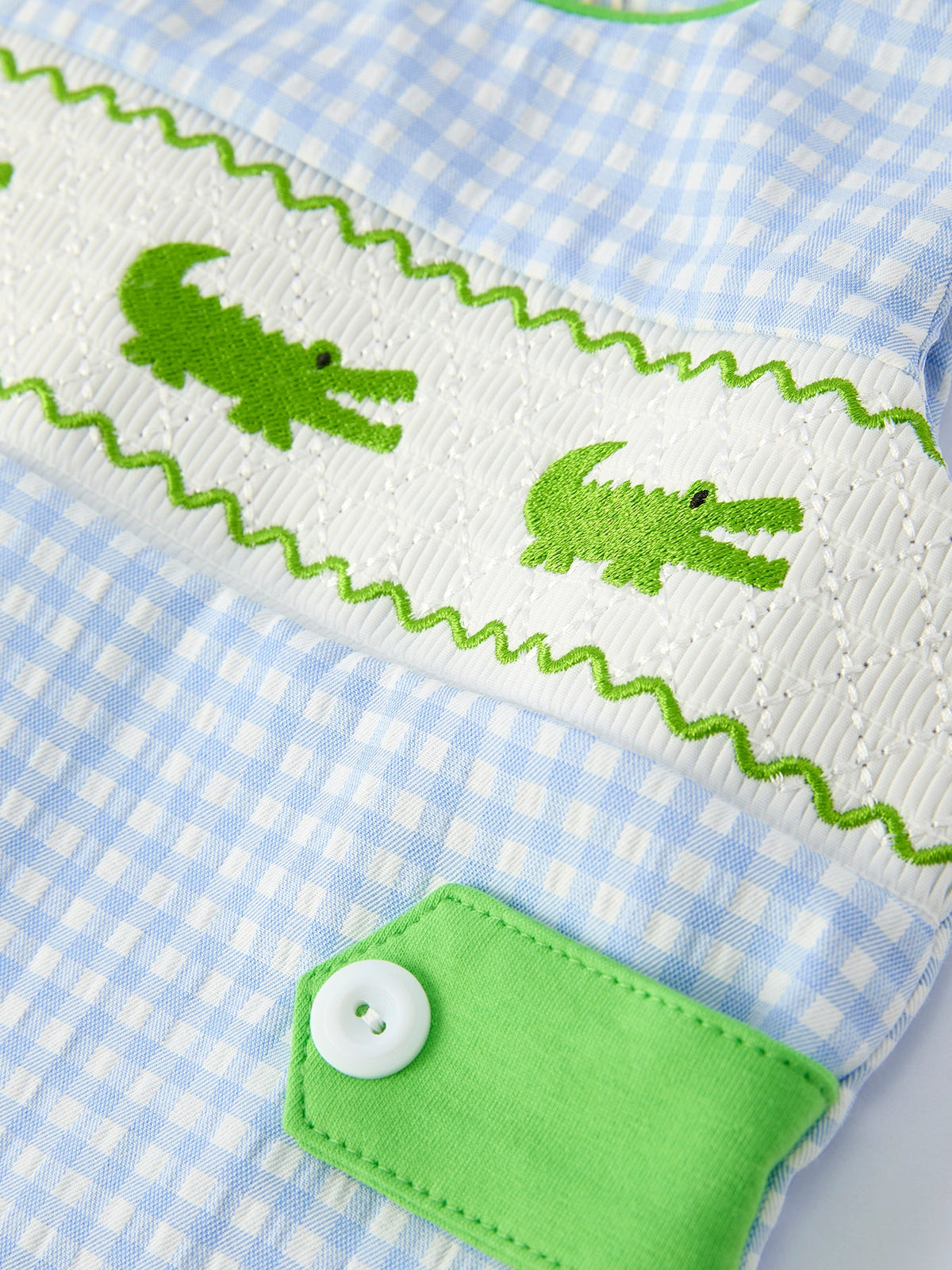 Rylee Faith Designs baby boys crocodile smocked romper in blue gingham with green crocodile embroidery and button detail