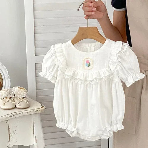 White baby bubble romper with ruffled collar and embroidered flower detail for infants