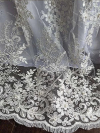close-up of white lace baby christening gown with bonnet featuring floral embroidery