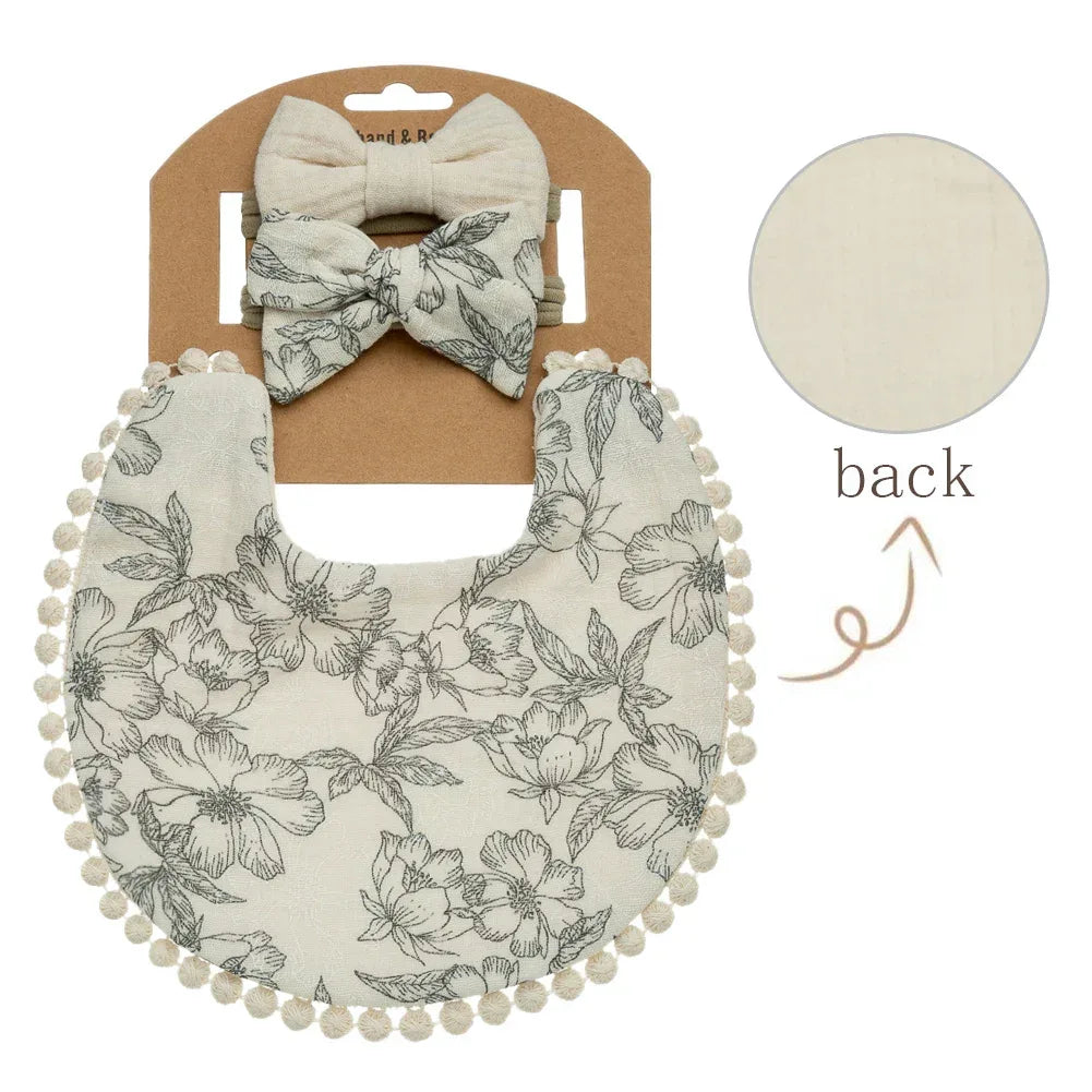 Neutral baby flower bib and headband set with floral print and pom pom trim for infants