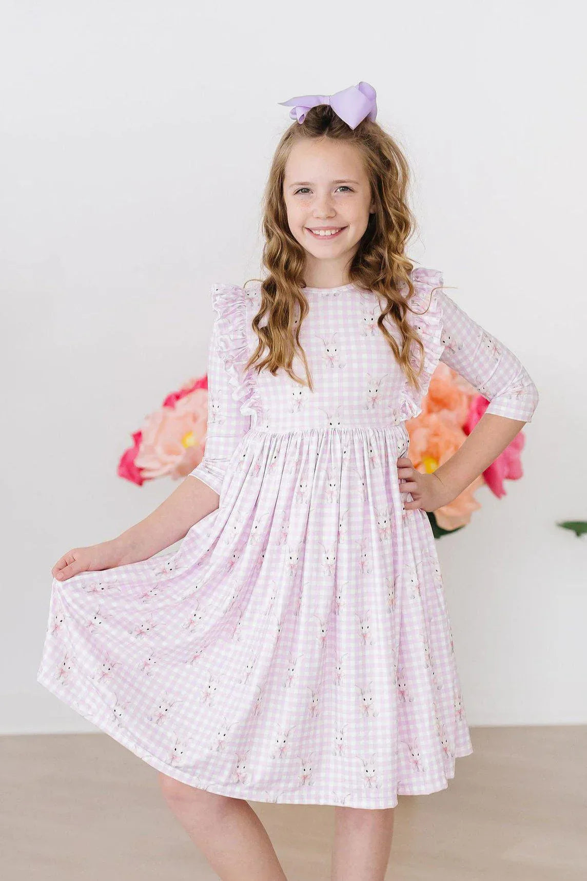Girl wearing pink baby girl bunny dress twirl ruffle dress 3/4 sleeves smiling with hand on hip
