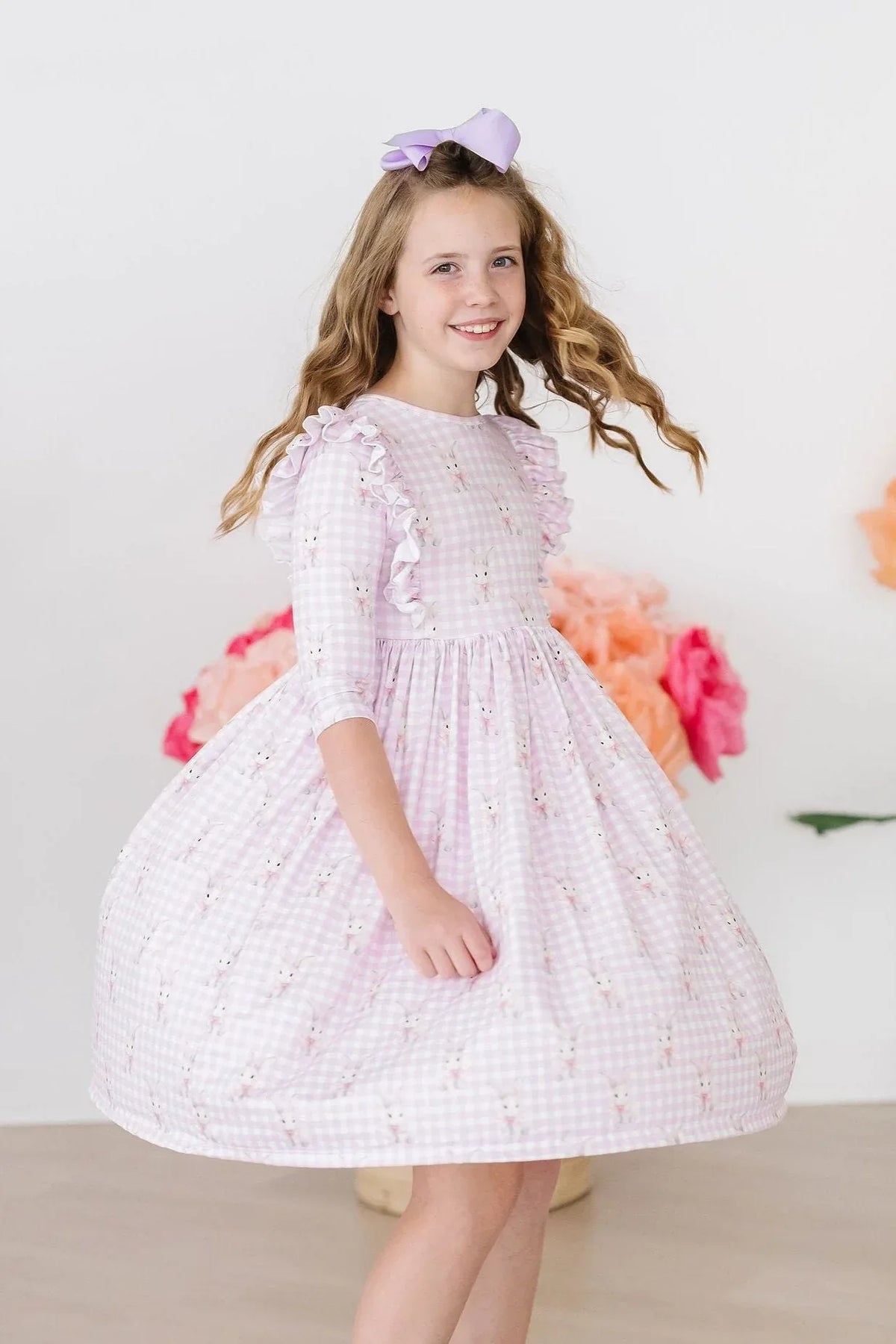 young girl wearing pink twirl ruffle dress with bunny print baby girl bunny dress smiling and spinning
