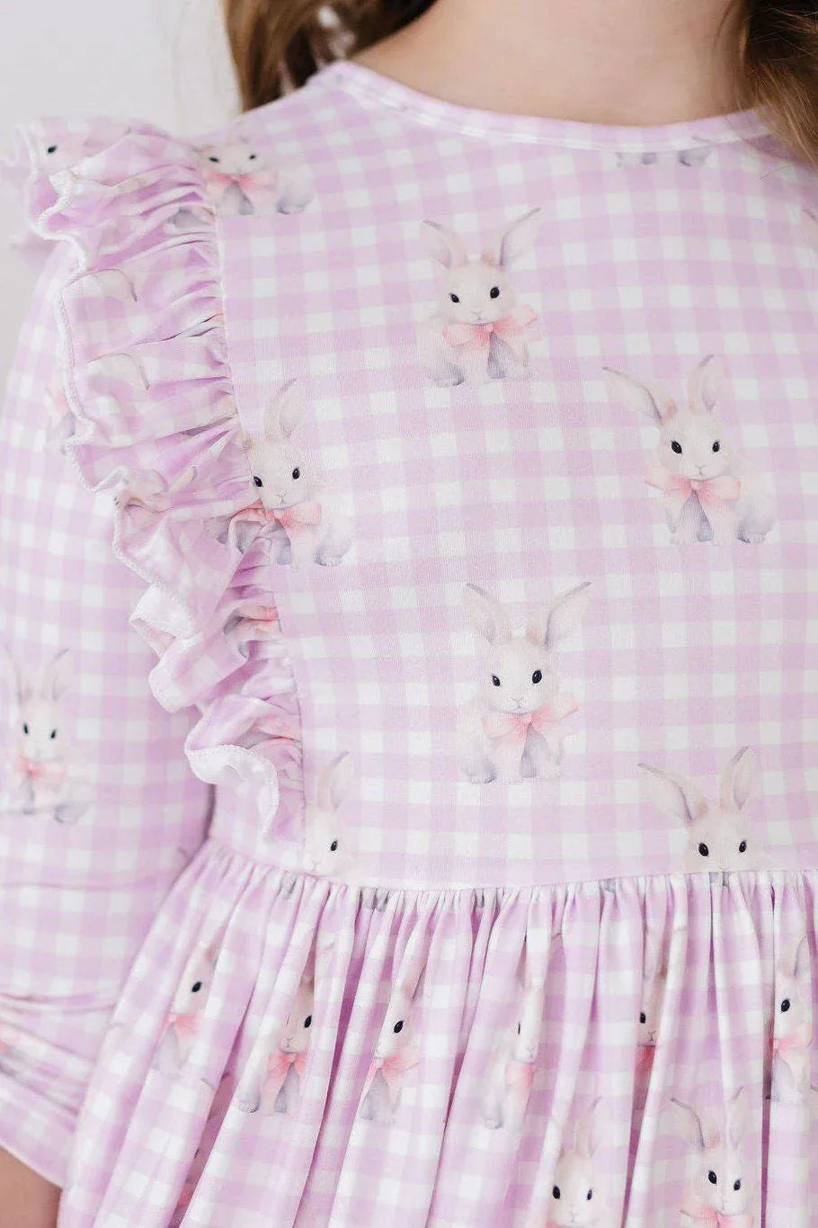 baby girl wearing pink and white checkered baby girl bunny dress with ruffle detail and long sleeves