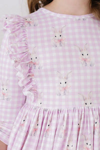 baby girl wearing pink and white checkered baby girl bunny dress with ruffle detail and long sleeves
