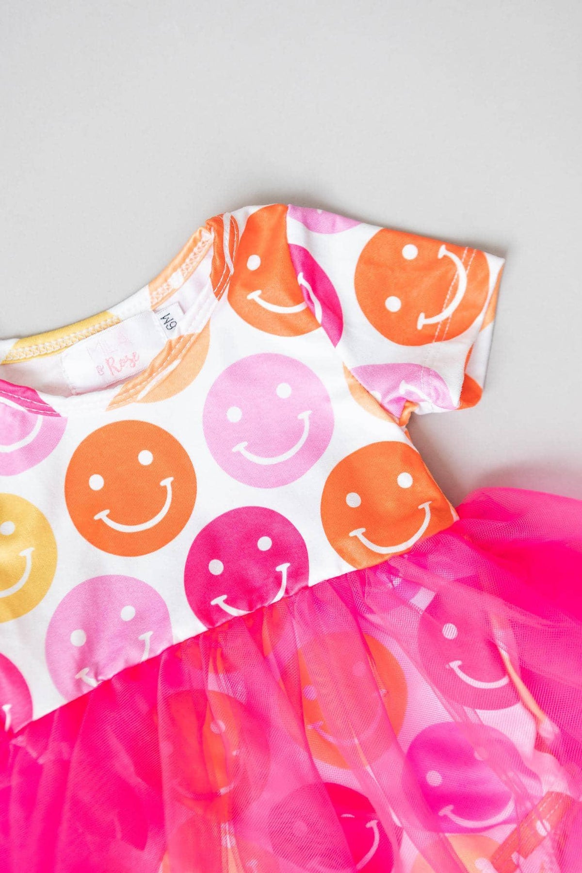 baby girl tutu bodysuit with colorful smiley face print and bright pink tulle skirt for infants