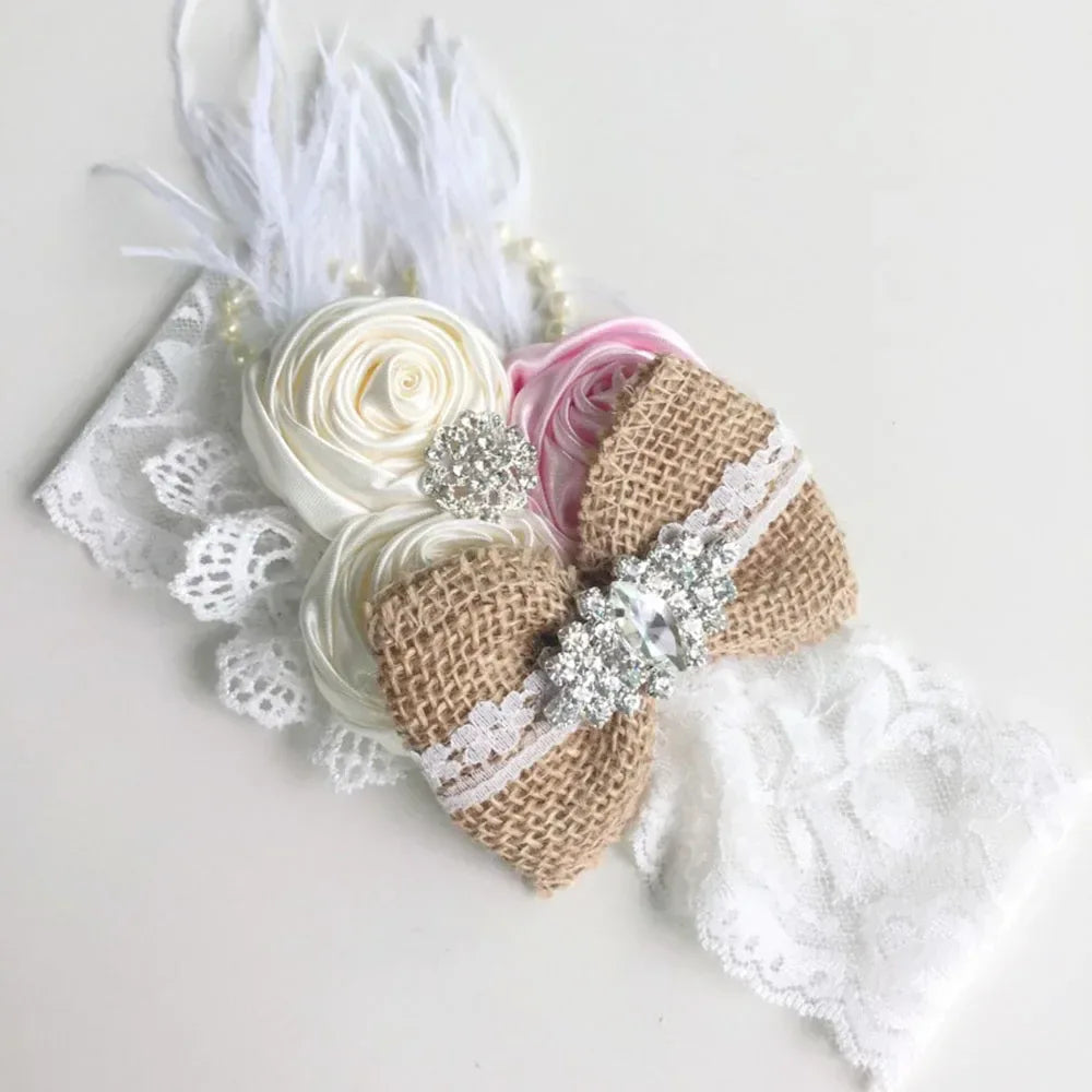 Elegant babies headpieces with white lace, burlap bow, cream and pink fabric flowers, and rhinestone accents