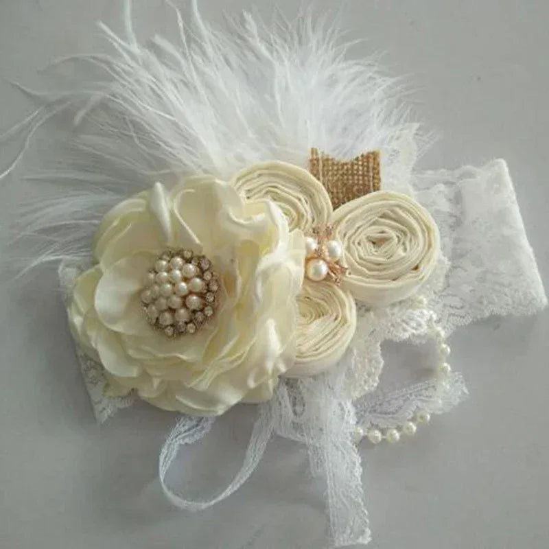 Ivory lace baby headpiece with pearl detailed fabric flowers and white feather accents