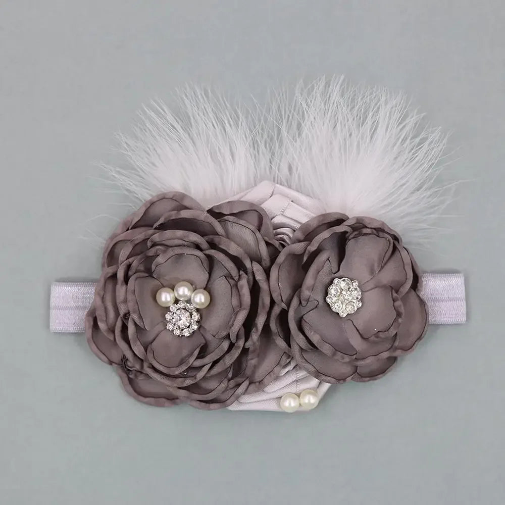 baby headpieces with gray fabric flowers, pearl and rhinestone accents, and white feather details