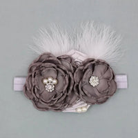 baby headpieces with gray fabric flowers, pearl and rhinestone accents, and white feather details