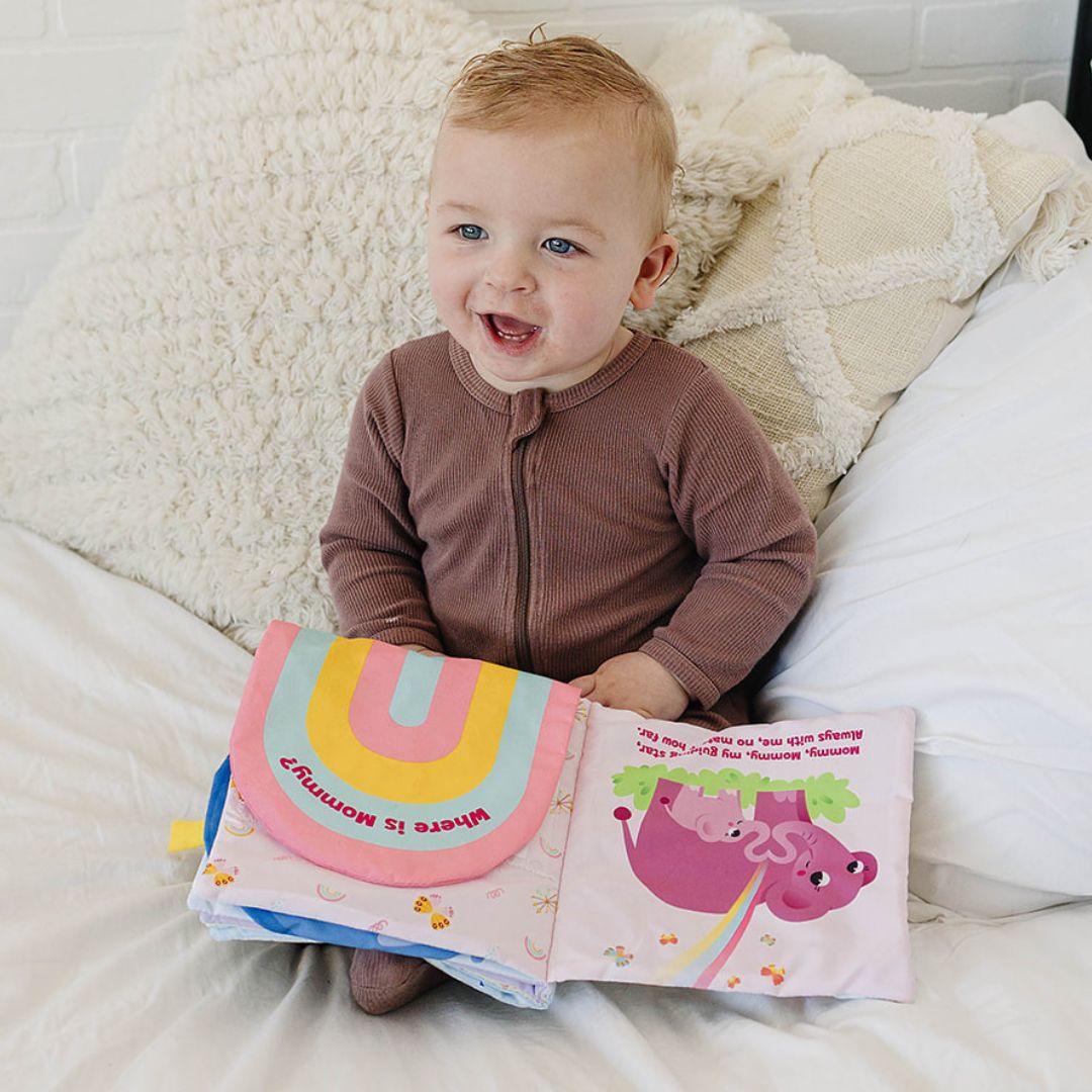 baby boy playing with Peek-A-Photo interactive cloth book, pastel colors, learning tool