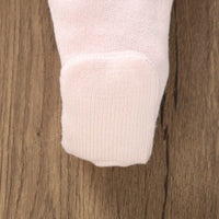 close up of pale pink baby knit dress cuff on wooden background