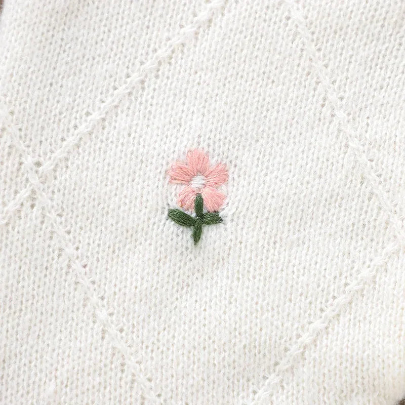 White cotton baby knit romper with flower design featuring delicate pink and green embroidery