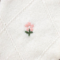 White cotton baby knit romper with flower design featuring delicate pink and green embroidery