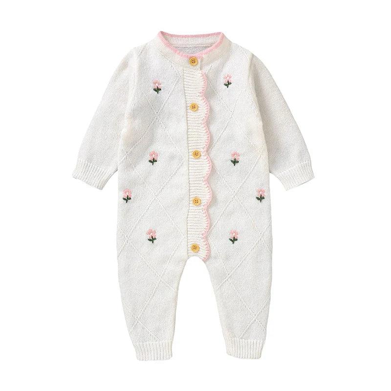 White cotton baby knit romper with flower design and pink scalloped trim with wooden buttons