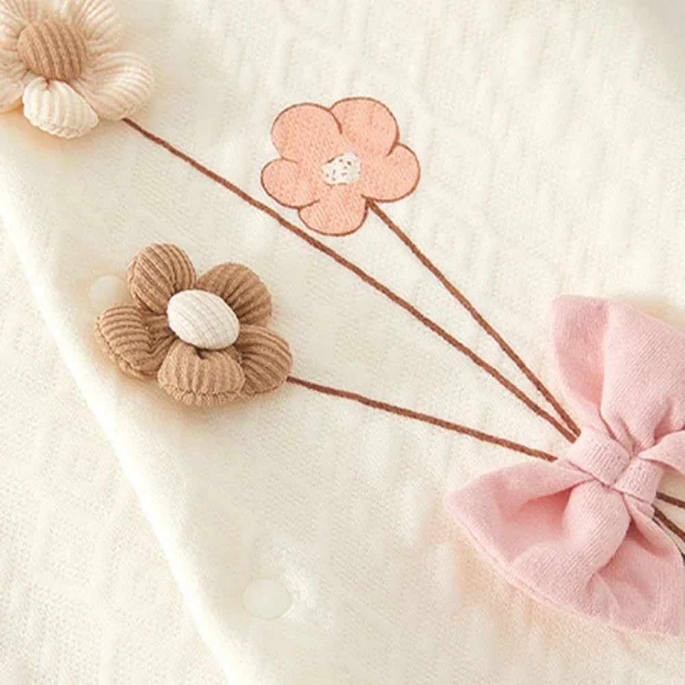 Cream baby knitted flower romper with pink and brown knitted flower accents and pink bow detail