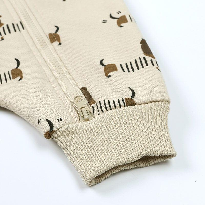 beige baby romper with dog print and zipper closure on sleeve cuff
