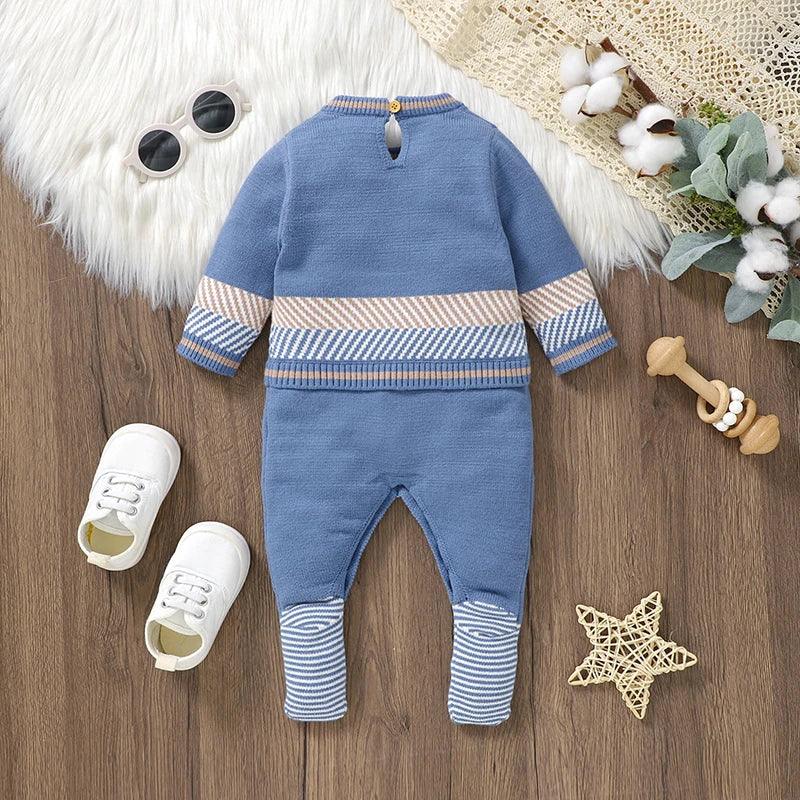 blue baby romper with striped cuffs and waistband for infants on wooden floor