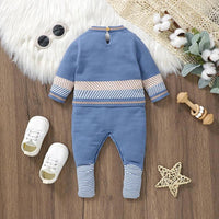 blue baby romper with striped cuffs and waistband for infants on wooden floor