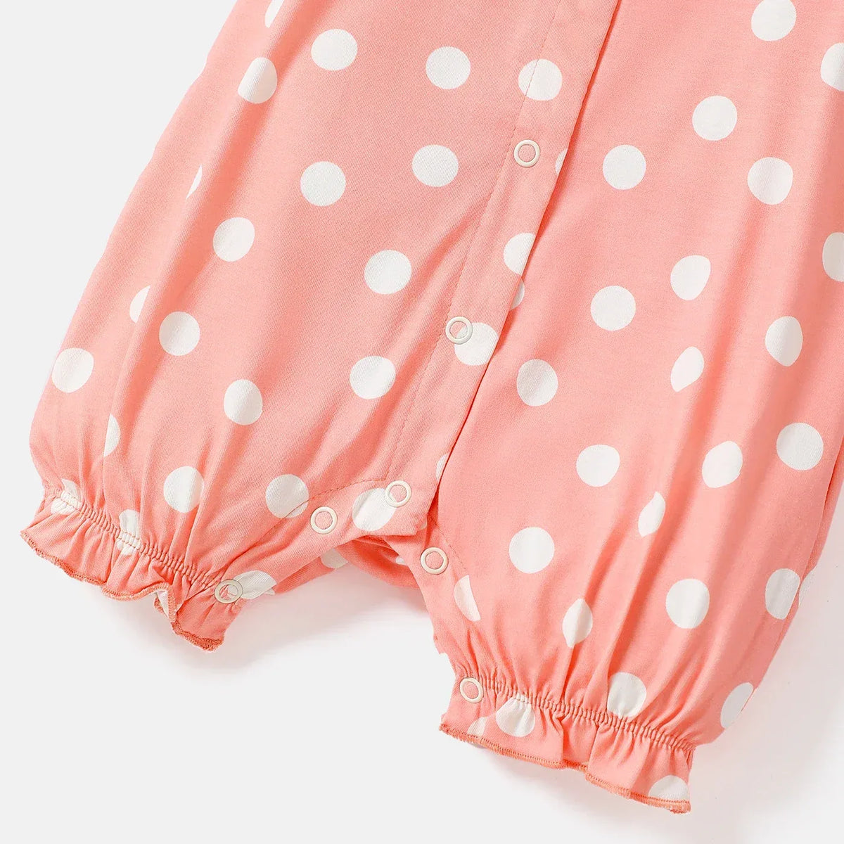 Coral pink baby romper with white polka dots and snap buttons, size for infants