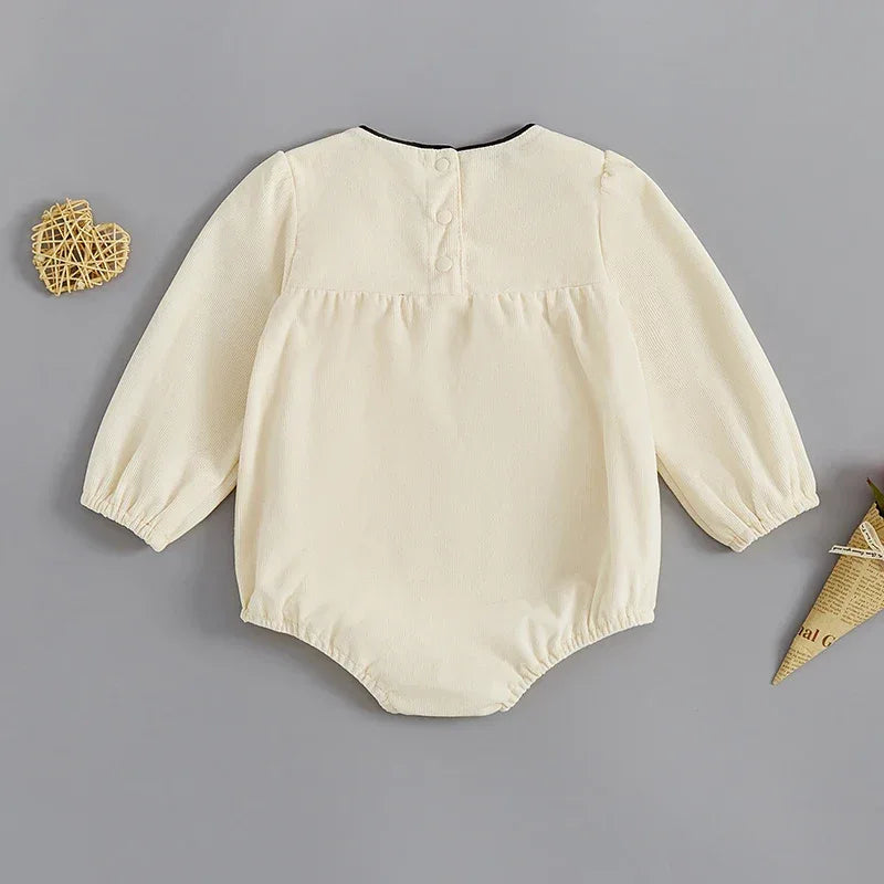 cream baby romper with oversized bow long sleeve for infants with button back closure