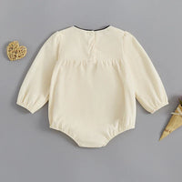 cream baby romper with oversized bow long sleeve for infants with button back closure