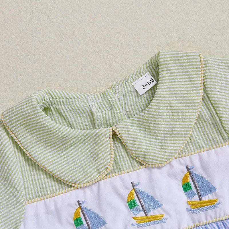 Baby Seersucker Romper with Sailboat Embroidery, green striped Peter Pan collar, multicolor sailboats on white panel.