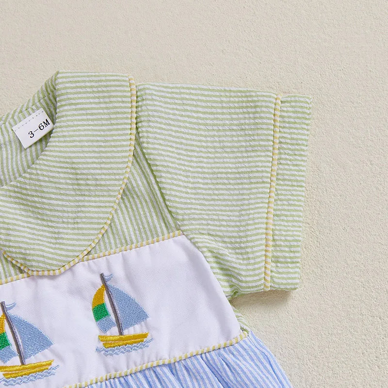 Baby seersucker romper with embroidered sailboats, Peter Pan collar, green stripes, multicolored sails.