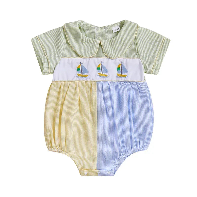 Baby seersucker romper with sailboat embroidery, Peter Pan collar, pastel green/yellow/blue panels.
