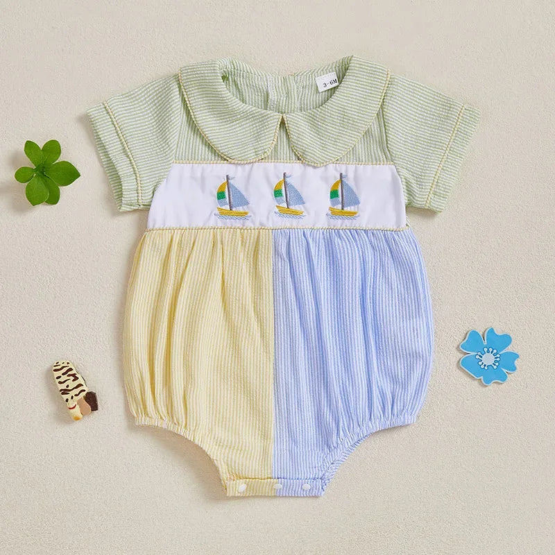 Baby seersucker romper with sailboat embroidery, Peter Pan collar, and pastel mint with yellow-blue color-blocks.