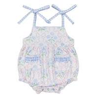 baby sunsuit with blue floral and pink bow print, adjustable tie straps, pockets, and ruffle details