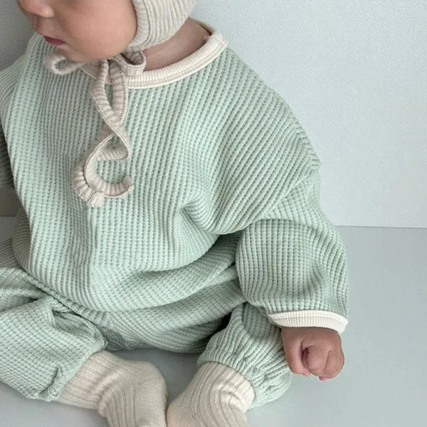 Mint green baby warm up outfit with cream trim and matching knit bonnet for infants