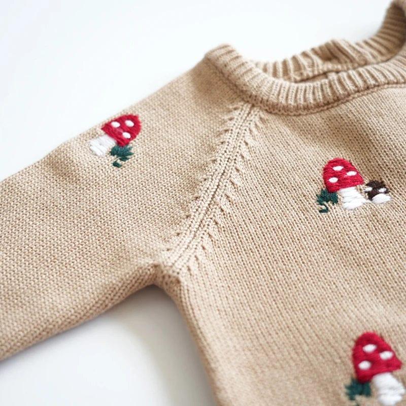 Beige baby winter romper with embroidered red mushroom designs, soft knit for infants