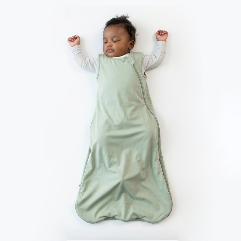 Infant sleeping in sage green sleep sack over grey undershirt on back