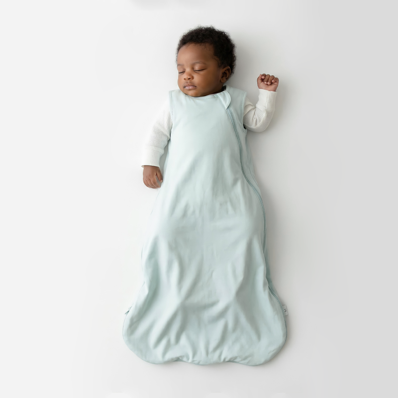 Infant sleeping in mint 0.5 TOG bamboo sleep sack over white shirt