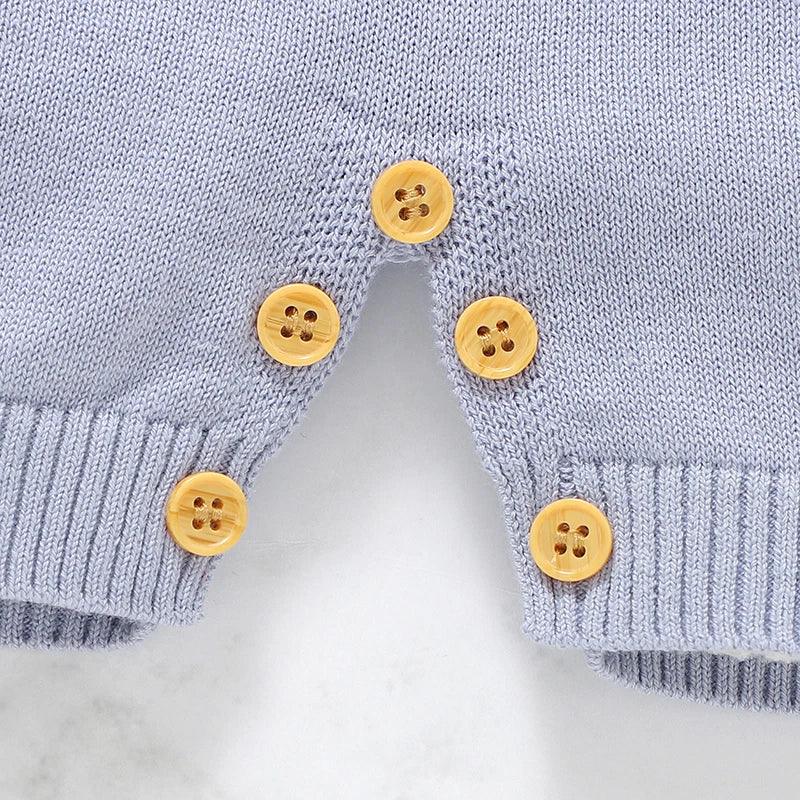 Light blue nautical baby romper for infants with wooden button details and ribbed cuffs
