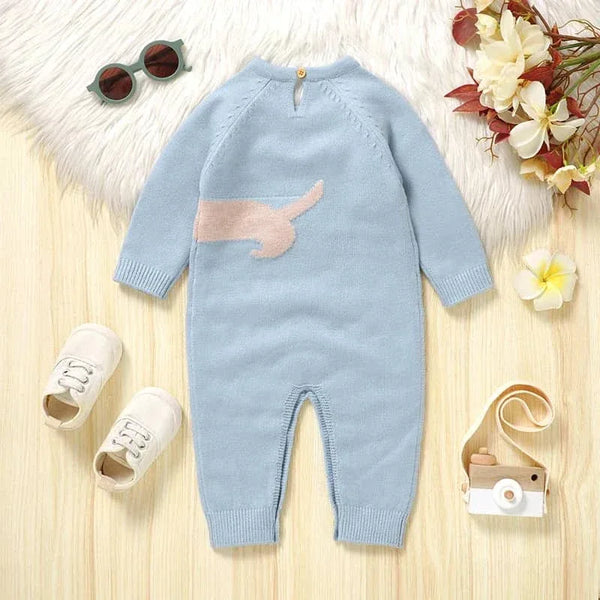 light blue dachshund baby sweater romper for infants laid flat with white shoes sunglasses and toy camera