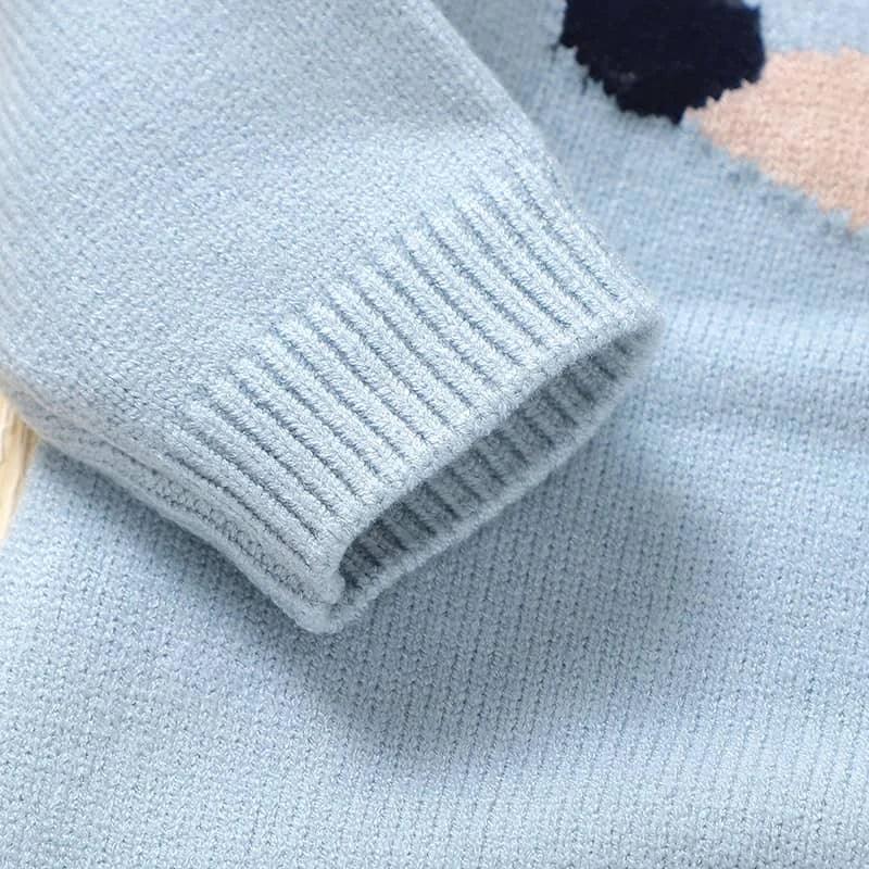 Close-up of light blue dachshund baby sweater romper sleeve and knit texture for infants