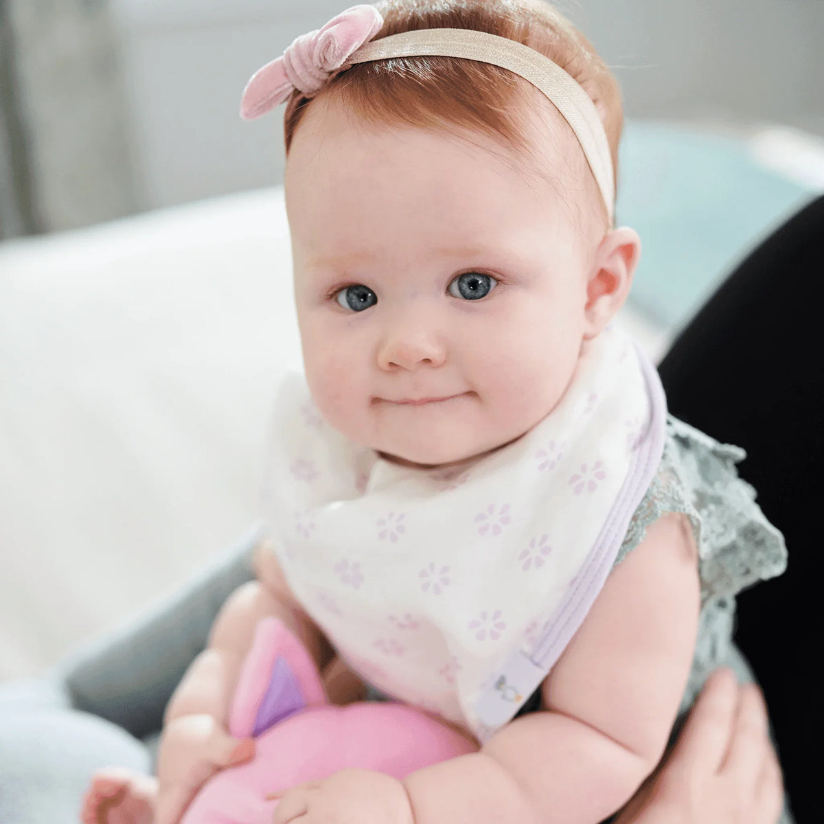 Baby wearing white and lavender bamboo muslin baby bib set with floral pattern and soft fabric
