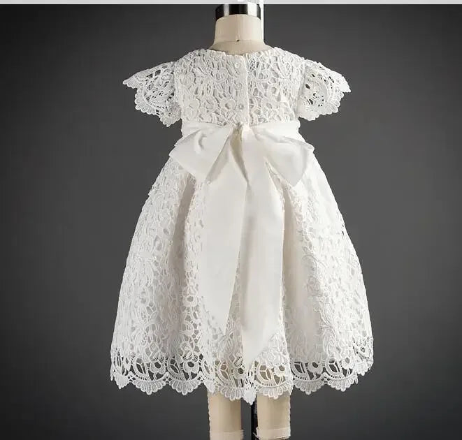 White lace baptism gown for baby with short sleeves and large bow detail at the back