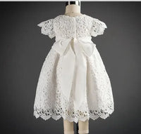 White lace baptism gown for baby with short sleeves and large bow detail at the back