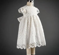 White baby baptism gown with intricate lace overlay and short puff sleeves