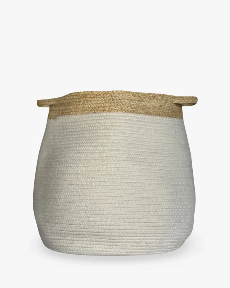 Creamy white coiled rope storage basket with beige seagrass rim and flat handles on white background