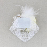 white beaded floral baby headband with lace, pearl beads, and feather detail for infants