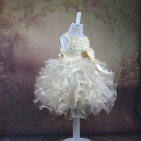 Ivory beaded special occasion dress for girls with ruffled skirt displayed on mannequin